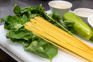 Wall Mural - Spaghetti product photo, on wood table with tomatoes and herbs and garlic