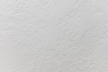 Rough wall decoration with white plaster, as a variant of modern interior decoration. Rough white wall. Texture or background for design