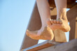 © Itxu - Close up of a child feet wrapped in sand on a day at the beach during the summer holidays. He is on top of the lifeguards' watchtower on a beach in the mediterranean sea. Moments of joy in childhood.