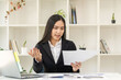 © ArLawKa - Asian businesswoman working on a laptop computer analyzing financial graphs on business issues Discuss the finances of startup projects