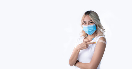 Portrait of Asian female wearing mask and doing victory sign after getting a second dose of vaccine on white background with copy space.