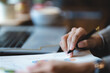 © chokniti - professional businessman making a business sign by a pen on deal contract document agreement paper, closeup on hand and paperwork signature form on corporate office table desk