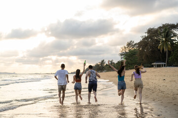 Group of Asian young man and woman having party on the beach together.