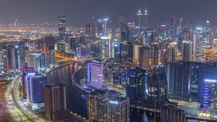 Skyline with modern architecture of Dubai business bay towers night timelapse. Aerial view