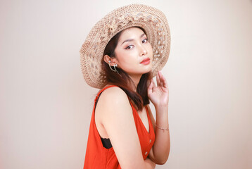 Wall Mural - Excited Asian woman in straw hat having beach vacation, isolated over white studio background.