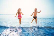Happy Children Playing Together In The Sea In Summer
