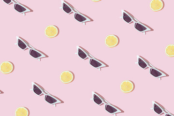 trendy pattern with stylish white sunglasses and lemon slice on pastel pink background. sunny day wa