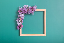 Summer Or Spring Composition On A Green Background. Lilac Flowers With Wooden Square With Copy Space Top View. Summer, Spring Floral Concept.