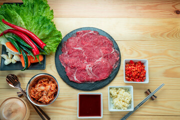 Wall Mural - Rare Sliced Wagyu beef, Cross Cut Short Ribs beef, Slide pork belly on black plate, Red beef on wooden background, Asian asian BBQ Shabu Shabu Sukiyaki food style.