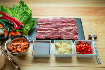 Wall Mural - Sliced Cross Cut Short Ribs beef on black plate, Beef Short Ribs (Sliced) on wooden background.