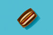 Classic hot dog with wurst, ketchup and mustard on blue background. Restaurant menu delivery tacke away concept