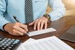 © C_Production - Businessman hands writing and signing check. business, finances and money concept.