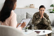 © Prostock-studio - Pensive military female sitting on couch during meeting with psychologist