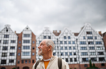 Wall Mural - Senior man tourist outdoors sightseeing in historic town.