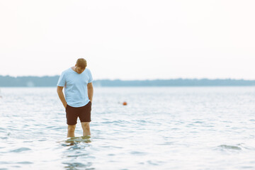 Wall Mural - man walking barefoot by sea beach summer time