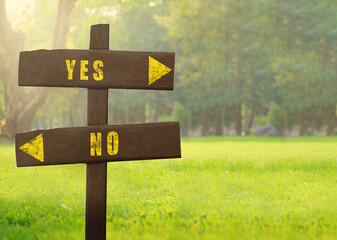 Wooden signs Yes versus No on a natural green background copy space.