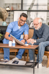 Wall Mural - Cheerful volunteer and a focused old man reading news together