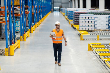 Wall Mural - A supervisor walking trough storage with documents in hands.