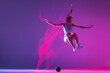 © master1305 - Young girl, athlete training isolated on blue studio background in mixed pink neon light. Healthy lifestyle, sport, motion and action concept.