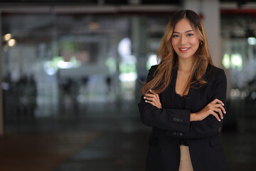 Portrait of a happy charming business woman looking at the camera in the office.