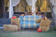Pumpkins And Straw Next To The Sofa.