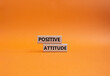 Positive attitude symbol. Concept words Positive attitude on wooden blocks. Beautiful orange background. Business and Positive attitude concept. Copy space.