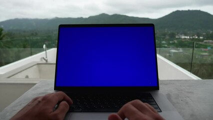 first-person portrait of business man working at laptop outside the office on the roof of beautiful mountains, blue screen chroma key. POV
