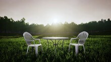 Round Table And Chairs On The Grass Field Garden At Morning, 3d Rendering