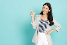 Young Beautiful Asian Business Woman Pointing To Empty Copy Space Isolated On Green Background