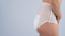 Side View Of A Woman In Adult Diapers On A White Background. Incontinence Problem. 