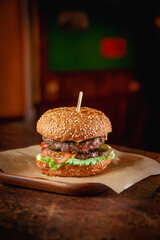 Wall Mural - Fresh tasty burger on a dark bar background