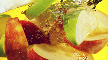 Wall Mural - Close up of green and red apple slices in water.