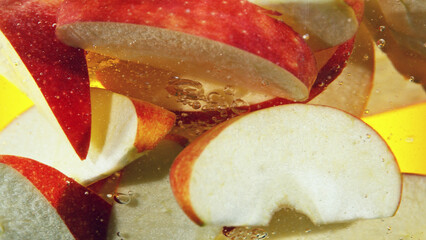 Wall Mural - Close up of red apple slices in water.