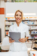© Dusko - Young and attractive female pharmacist working in a drugstore. She is happy and smiled.