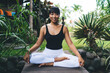 © BullRun - Asian girl practicing yoga in tropical garden