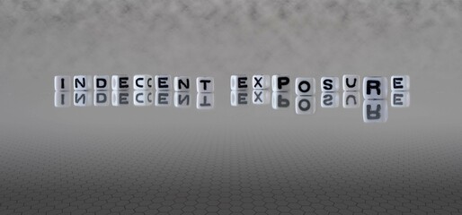 Wall Mural - indecent exposure word or concept represented by black and white letter cubes on a grey horizon background stretching to infinity