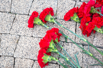 Wall Mural - Flowers on stones, a bouquet of flowers on a stone path. Wreath at the grave.