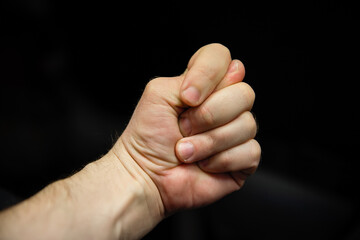 A man's hand shows a fig.