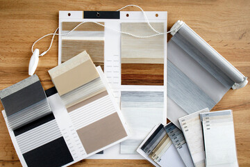 Samples of fabrics of different textures and colors in the form of a catalog for the selection of fabrics for fabric blinds. Samples of blinds day and night.