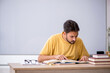 © Elnur - Young male student preparing for exams in the classroom