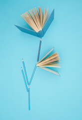 Wall Mural - Pastel blue books and pencils on bright blue background. Education, knowledge or Nature concept. Flat lay.