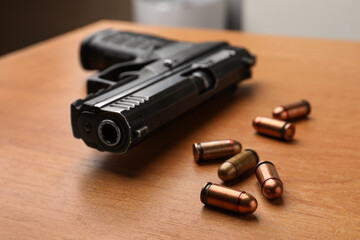 Wall Mural - Semi-automatic pistol and bullets on wooden table indoors, closeup