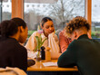 © Cultura Creative - Group of young friends sitting at restaurant table