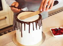 Lifestyle, People, Cooking And Freelance Concept: Female Hands Decorate The Cake With Chocolate