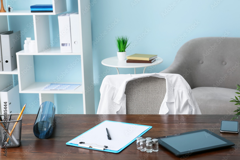 Doctor's workplace with tablet computer in interior of modern medical office