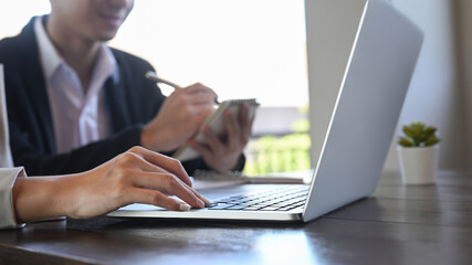 Cropped shot businesspeople sharing ideas, discussing business strategy together at co working space.