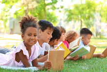 Cute Little Children Reading Books In Park