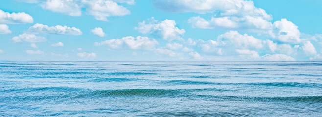 Wall Mural - Blue sea water panorama with waves and white clouds