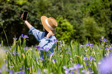 Poster - Woman take selfie on phone in the flower garden