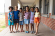 © wavebreak3 - Portrait of smiling multiracial elementary school students with arm around standing in corridor